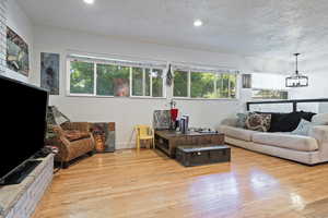 Living room featuring visible vents, recessed lighting, a textured ceiling, and wood-type flooring