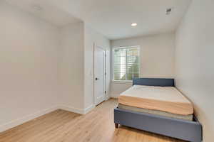 Bedroom with recessed lighting, light wood-style floors, and baseboards