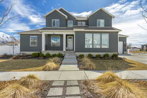 View of front facade featuring a garage, covered porch, and driveway