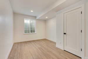 Spare room with recessed lighting, light wood-type flooring, and baseboards