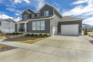 View of front of property featuring fence, driveway, a porch, an attached garage, and a mountain view