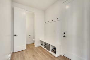 Mudroom featuring light wood-style flooring and baseboards