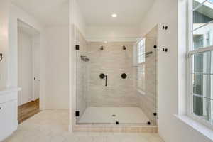 Bathroom featuring tile patterned flooring, a shower stall, and baseboards