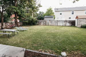 View of BACK yard featuring an outbuilding, a fenced backyard, and a shed
