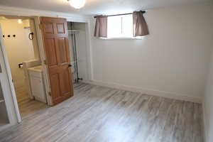 Unfurnished bedroom with a closet, baseboards, and light wood finished floors