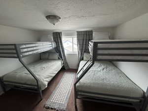 Bedroom featuring carpet and a textured ceiling
