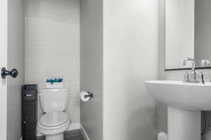 Bathroom with toilet, baseboards, and a sink