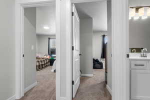 Corridor with carpet, baseboards, and a textured ceiling