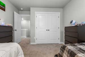 Bedroom with carpet, a closet, and baseboards