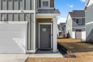 Property entrance featuring a standing seam roof, a garage, and metal roof