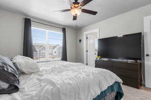 Bedroom featuring light carpet, a textured ceiling, and a ceiling fan