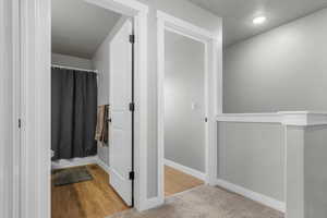 Bathroom with curtained shower, baseboards, and a textured ceiling
