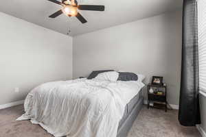 Carpeted bedroom with baseboards and a ceiling fan