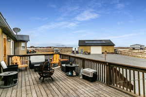 Wooden terrace with an outdoor structure and a fire pit