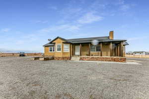 View of front of property featuring stucco siding, fence, and a shingled roof