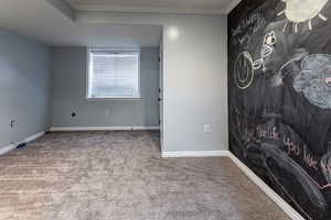 Carpeted empty room with crown molding and baseboards