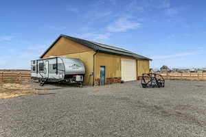 View of outbuilding with an outbuilding, fence, and driveway