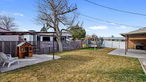 View of yard with a playset, a fenced backyard, and a patio area