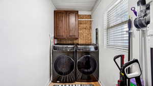 Laundry room featuring plenty of natural light, cabinet space, washer and dryer.