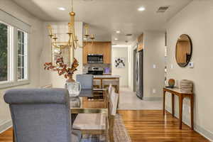 Dining space with recessed lighting, light wood-style floors, visible vents, and baseboards