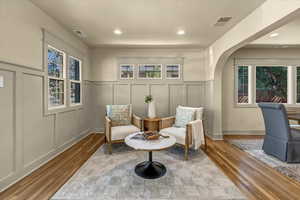 Sitting room featuring a decorative wall, visible vents, and arched walkways