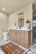 Bathroom featuring vanity, a shower stall, toilet, and marble finish floor