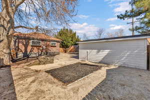 View of yard featuring an outbuilding, a patio area, and fence