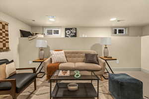 Living area with recessed lighting, visible vents, and baseboards