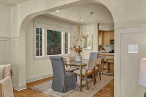 Dining area with recessed lighting, visible vents, arched walkways, and light wood-style flooring