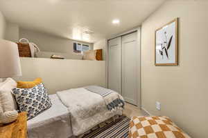 Bedroom with visible vents, light colored carpet, and a closet