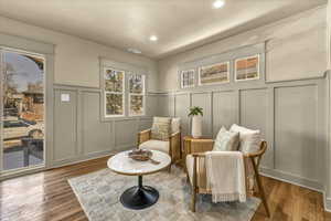 Sitting room featuring a decorative wall, recessed lighting, wood finished floors, and visible vents