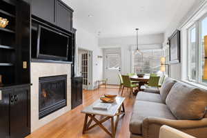 Living room featuring recessed lighting, light wood-style flooring, and a fireplace