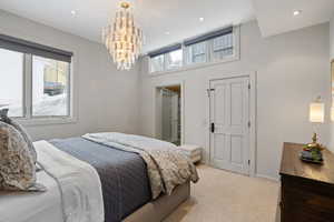 Bedroom featuring a notable chandelier, recessed lighting, light colored carpet, and baseboards