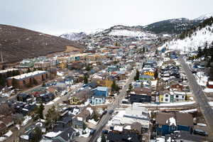 Snowy aerial view with a mountain view and a residential view