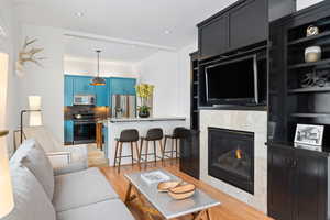 Living room with light wood finished floors, recessed lighting, and a tile fireplace