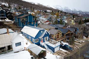 Snowy aerial view featuring a mountain view and a residential view