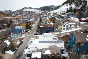 Snowy aerial view featuring a mountain view and a residential view