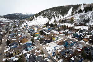 Snowy aerial view featuring a mountain view and a residential view