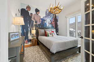 Bedroom featuring an inviting chandelier and wood finished floors