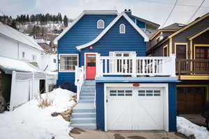 View of front of home featuring a chimney and a garage