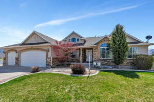 Craftsman inspired home featuring a shingled roof, concrete driveway, an attached garage, stone siding, and a front yard