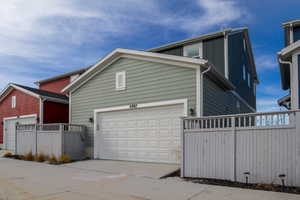 Alleyway view of back of home featuring board and batten siding & fenced in yard