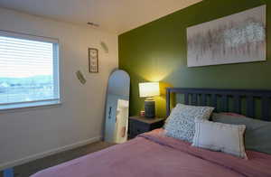 Bedroom featuring visible vents, baseboards, and carpet