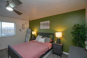Bedroom featuring baseboards, arched walkways, ceiling fan, and carpet flooring