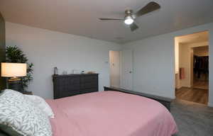 Bedroom featuring visible vents, wood finished floors, ensuite bath, baseboards, and ceiling fan