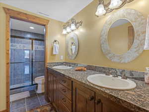 Bathroom featuring tile patterned floors, toilet, visible vents, and a sink