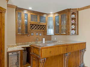 Bar featuring beverage cooler, recessed lighting, and wet bar