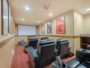 Carpeted home theater featuring recessed lighting and baseboards