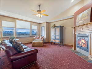 Carpeted living room featuring a fireplace with flush hearth, recessed lighting, crown molding, baseboards, and vaulted ceiling