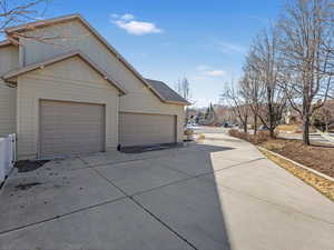 View of side of home with driveway and an attached garage